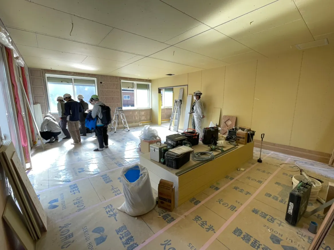 内装中間検査の様子。壁の下地が組まれた室内で関係者が検査を行っている