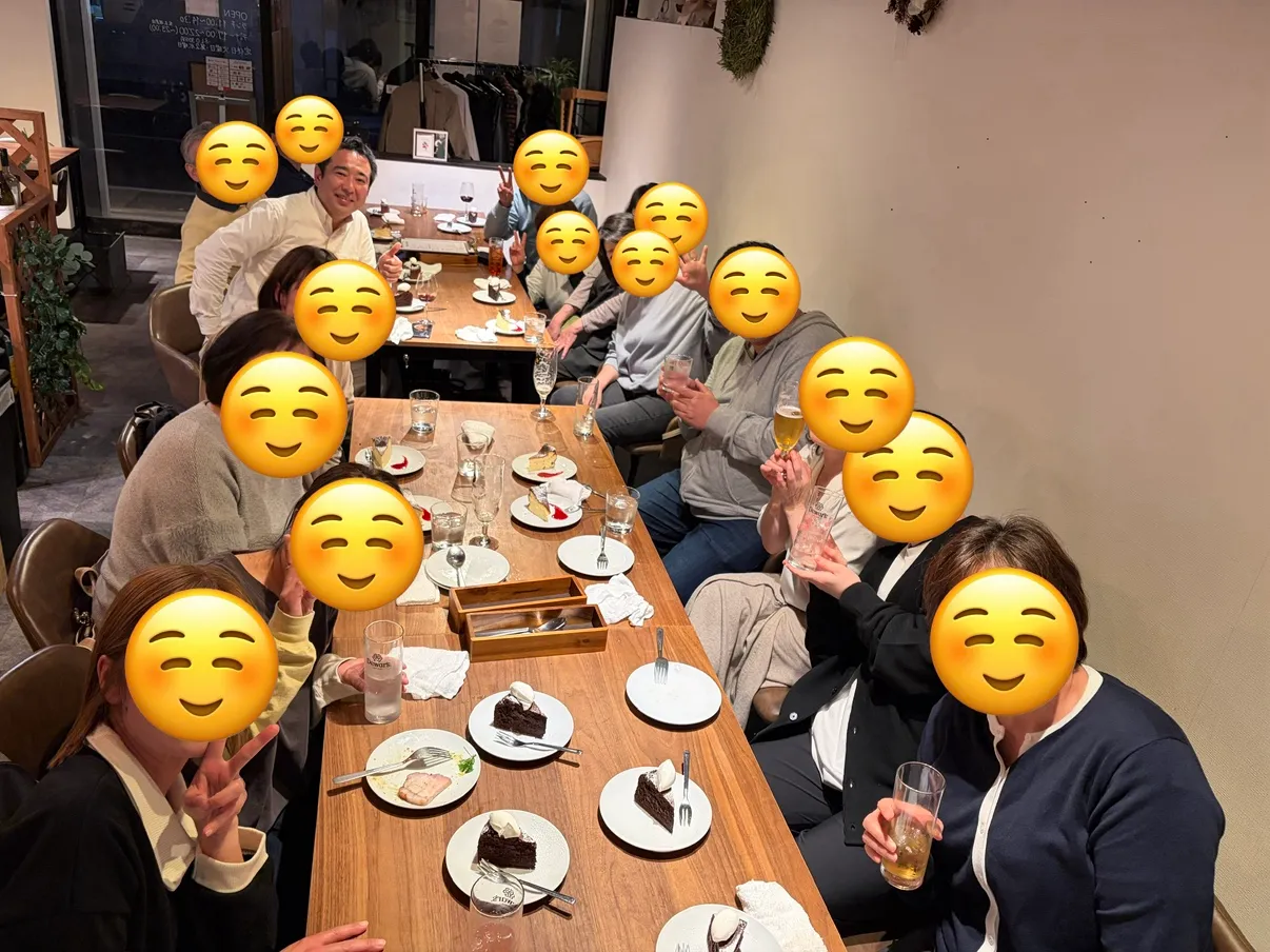 親睦会の様子。長いテーブルを囲んで食事を楽しむスタッフたち
