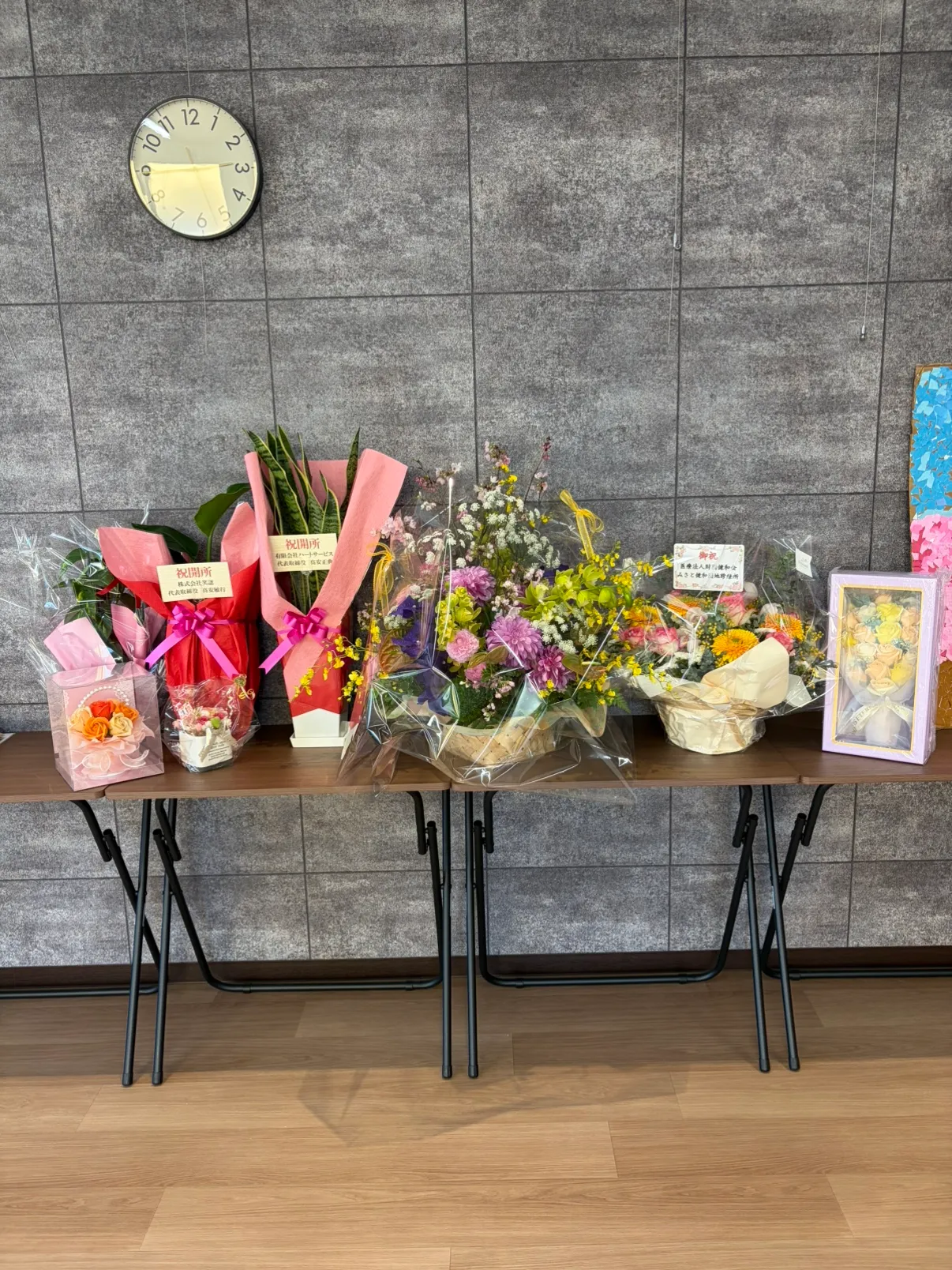 内覧会に寄せられたお祝いの花や記念品が、テーブルいっぱいに並んでいる様子